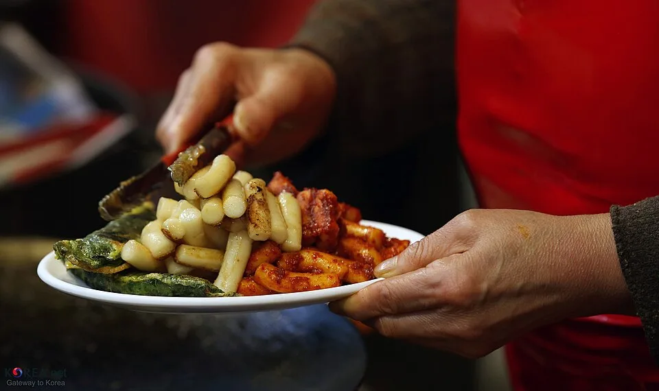 접시에 반찬을 담는 손